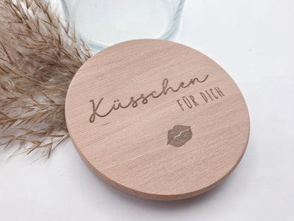 Dekoratives Geschenkglas aus klarem Glas mit hochwertigem Buchenholzdeckel und feiner Gravur „Küsschen für dich“. Das minimalistische Design im Scandi-Stil macht das Glas zu einer liebevollen Geschenkidee für Valentinstag, Muttertag, Geburtstag oder als kleine Aufmerksamkeit für Herzensmenschen. Ideal zum individuellen Befüllen mit Süßigkeiten oder Botschaften. Die abgebildeten Süßigkeiten sind Dekoration und nicht im Lieferumfang enthalten.