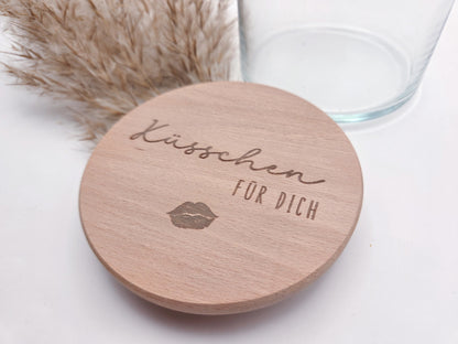 Dekoratives Geschenkglas aus klarem Glas mit hochwertigem Buchenholzdeckel und feiner Gravur „Küsschen für dich“. Das minimalistische Design im Scandi-Stil macht das Glas zu einer liebevollen Geschenkidee für Valentinstag, Muttertag, Geburtstag oder als kleine Aufmerksamkeit für Herzensmenschen. Ideal zum individuellen Befüllen mit Süßigkeiten oder Botschaften. Die abgebildeten Süßigkeiten sind Dekoration und nicht im Lieferumfang enthalten.