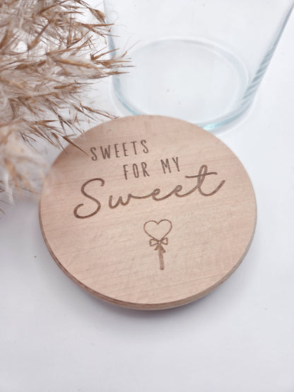 Dekoratives Geschenkglas aus transparentem Glas mit hochwertigem Buchenholzdeckel und liebevoller Lasergravur „Sweets for my Sweet“. Das Glas wird leer geliefert und eignet sich ideal zum individuellen Befüllen mit Süßigkeiten, Pralinen oder kleinen Überraschungen. Zeitloses, minimalistisches Design im Scandi Stil, perfekt als Geschenk zum Valentinstag, Geburtstag, Jahrestag oder für einen Herzensmenschen. Nachhaltig, hochwertig und wiederverwendbar.