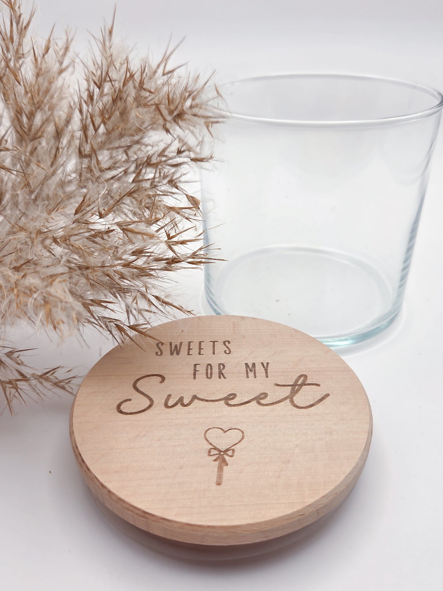 Dekoratives Geschenkglas aus transparentem Glas mit hochwertigem Buchenholzdeckel und liebevoller Lasergravur „Sweets for my Sweet“. Das Glas wird leer geliefert und eignet sich ideal zum individuellen Befüllen mit Süßigkeiten, Pralinen oder kleinen Überraschungen. Zeitloses, minimalistisches Design im Scandi Stil, perfekt als Geschenk zum Valentinstag, Geburtstag, Jahrestag oder für einen Herzensmenschen. Nachhaltig, hochwertig und wiederverwendbar.
