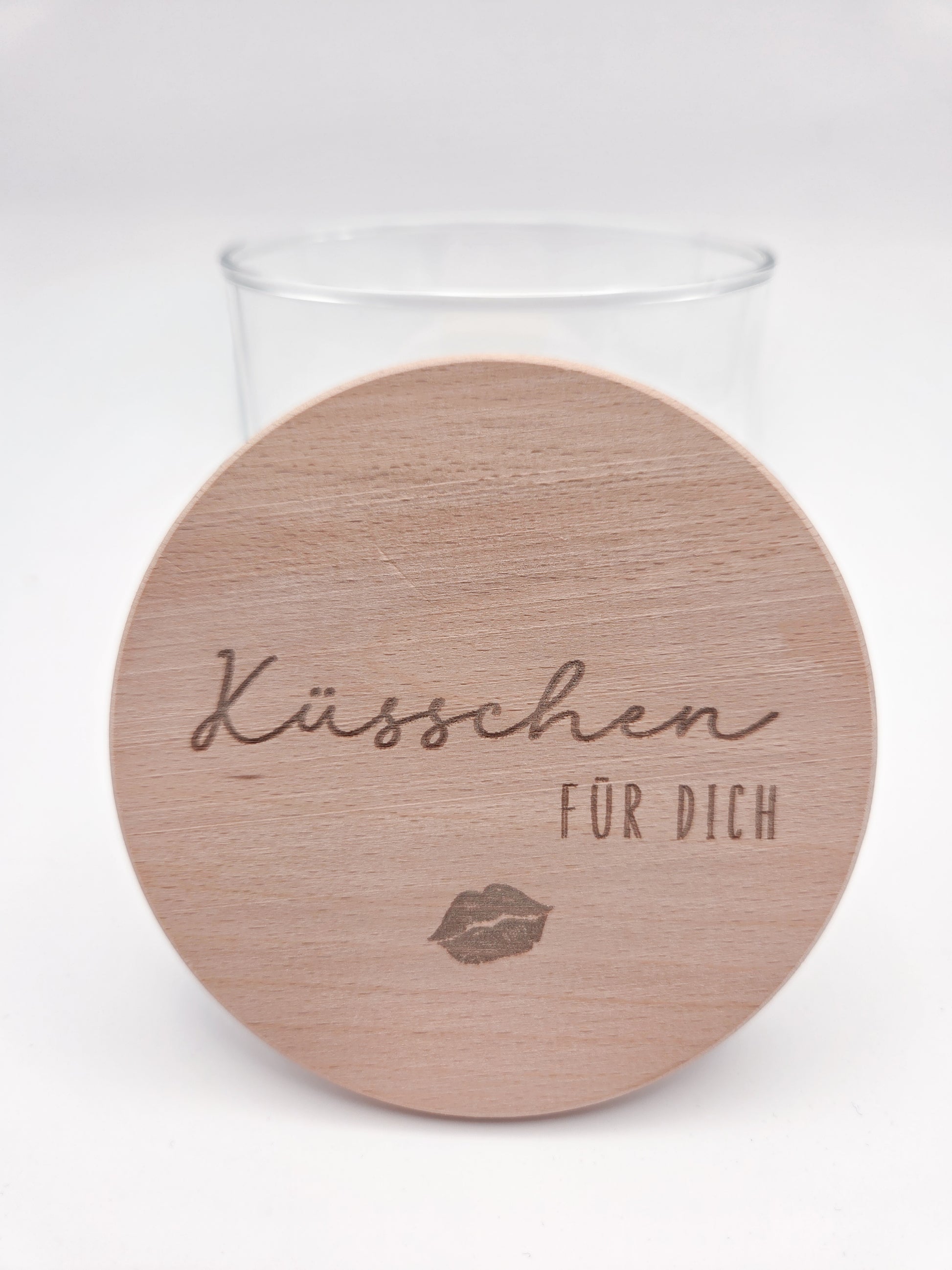 Dekoratives Geschenkglas aus klarem Glas mit hochwertigem Buchenholzdeckel und feiner Gravur „Küsschen für dich“. Das minimalistische Design im Scandi-Stil macht das Glas zu einer liebevollen Geschenkidee für Valentinstag, Muttertag, Geburtstag oder als kleine Aufmerksamkeit für Herzensmenschen. Ideal zum individuellen Befüllen mit Süßigkeiten oder Botschaften. Die abgebildeten Süßigkeiten sind Dekoration und nicht im Lieferumfang enthalten.v