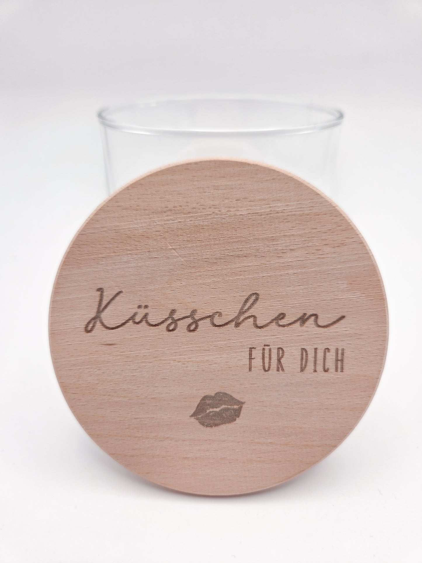 Dekoratives Geschenkglas aus klarem Glas mit hochwertigem Buchenholzdeckel und feiner Gravur „Küsschen für dich“. Das minimalistische Design im Scandi-Stil macht das Glas zu einer liebevollen Geschenkidee für Valentinstag, Muttertag, Geburtstag oder als kleine Aufmerksamkeit für Herzensmenschen. Ideal zum individuellen Befüllen mit Süßigkeiten oder Botschaften. Die abgebildeten Süßigkeiten sind Dekoration und nicht im Lieferumfang enthalten.