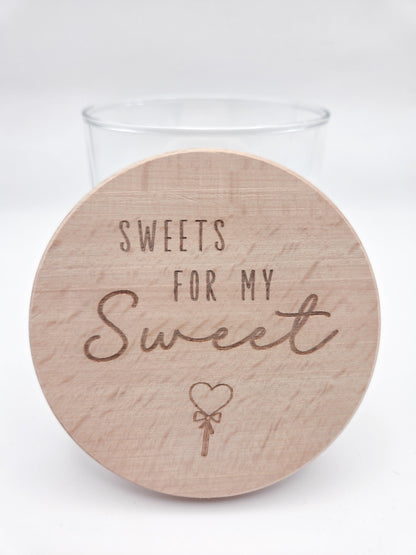 Dekoratives Geschenkglas aus transparentem Glas mit hochwertigem Buchenholzdeckel und liebevoller Lasergravur „Sweets for my Sweet“. Das Glas wird leer geliefert und eignet sich ideal zum individuellen Befüllen mit Süßigkeiten, Pralinen oder kleinen Überraschungen. Zeitloses, minimalistisches Design im Scandi Stil, perfekt als Geschenk zum Valentinstag, Geburtstag, Jahrestag oder für einen Herzensmenschen. Nachhaltig, hochwertig und wiederverwendbar.
