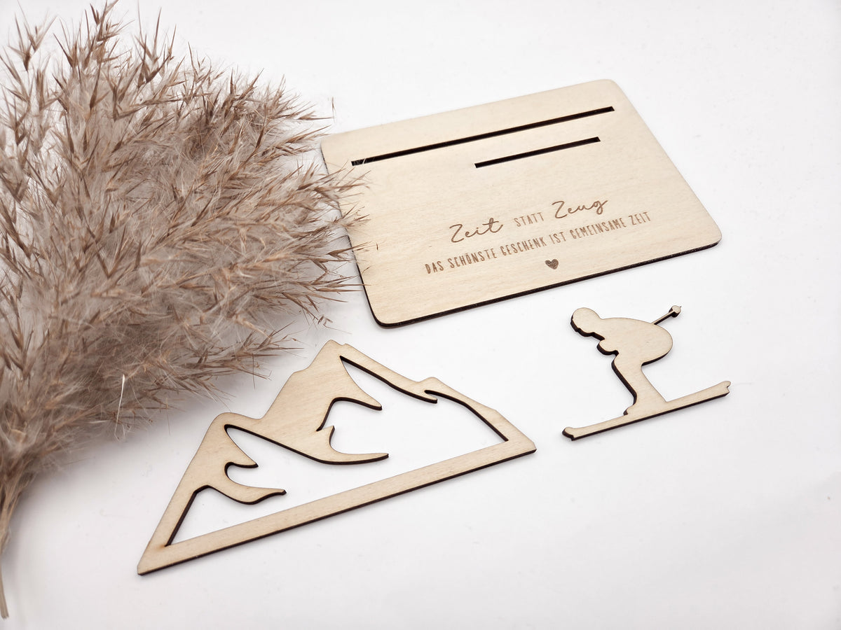 Geschenkkarte aus Holz mit filigranem Skifahrer vor einer Bergkulisse und der Gravur „Zeit statt Zeug – Das schönste Geschenk ist gemeinsame Zeit“. Die besondere Holzkarte eignet sich ideal als Geldgeschenk für Skiurlaub, Skitag oder Winterurlaub sowie als Gutschein für gemeinsame Erlebnisse. Eine kreative Geschenkidee für Skifahrer, Bergliebhaber, Paare, Freunde und Familie zu Geburtstag, Weihnachten oder Jahrestag – natürlich und liebevoll gestaltet.