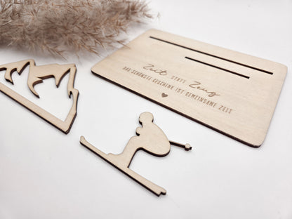 Geschenkkarte aus Holz mit filigranem Skifahrer vor einer Bergkulisse und der Gravur „Zeit statt Zeug – Das schönste Geschenk ist gemeinsame Zeit“. Die besondere Holzkarte eignet sich ideal als Geldgeschenk für Skiurlaub, Skitag oder Winterurlaub sowie als Gutschein für gemeinsame Erlebnisse. Eine kreative Geschenkidee für Skifahrer, Bergliebhaber, Paare, Freunde und Familie zu Geburtstag, Weihnachten oder Jahrestag – natürlich und liebevoll gestaltet.