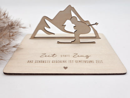Geschenkkarte aus Holz mit filigranem Skifahrer vor einer Bergkulisse und der Gravur „Zeit statt Zeug – Das schönste Geschenk ist gemeinsame Zeit“. Die besondere Holzkarte eignet sich ideal als Geldgeschenk für Skiurlaub, Skitag oder Winterurlaub sowie als Gutschein für gemeinsame Erlebnisse. Eine kreative Geschenkidee für Skifahrer, Bergliebhaber, Paare, Freunde und Familie zu Geburtstag, Weihnachten oder Jahrestag – natürlich und liebevoll gestaltet.