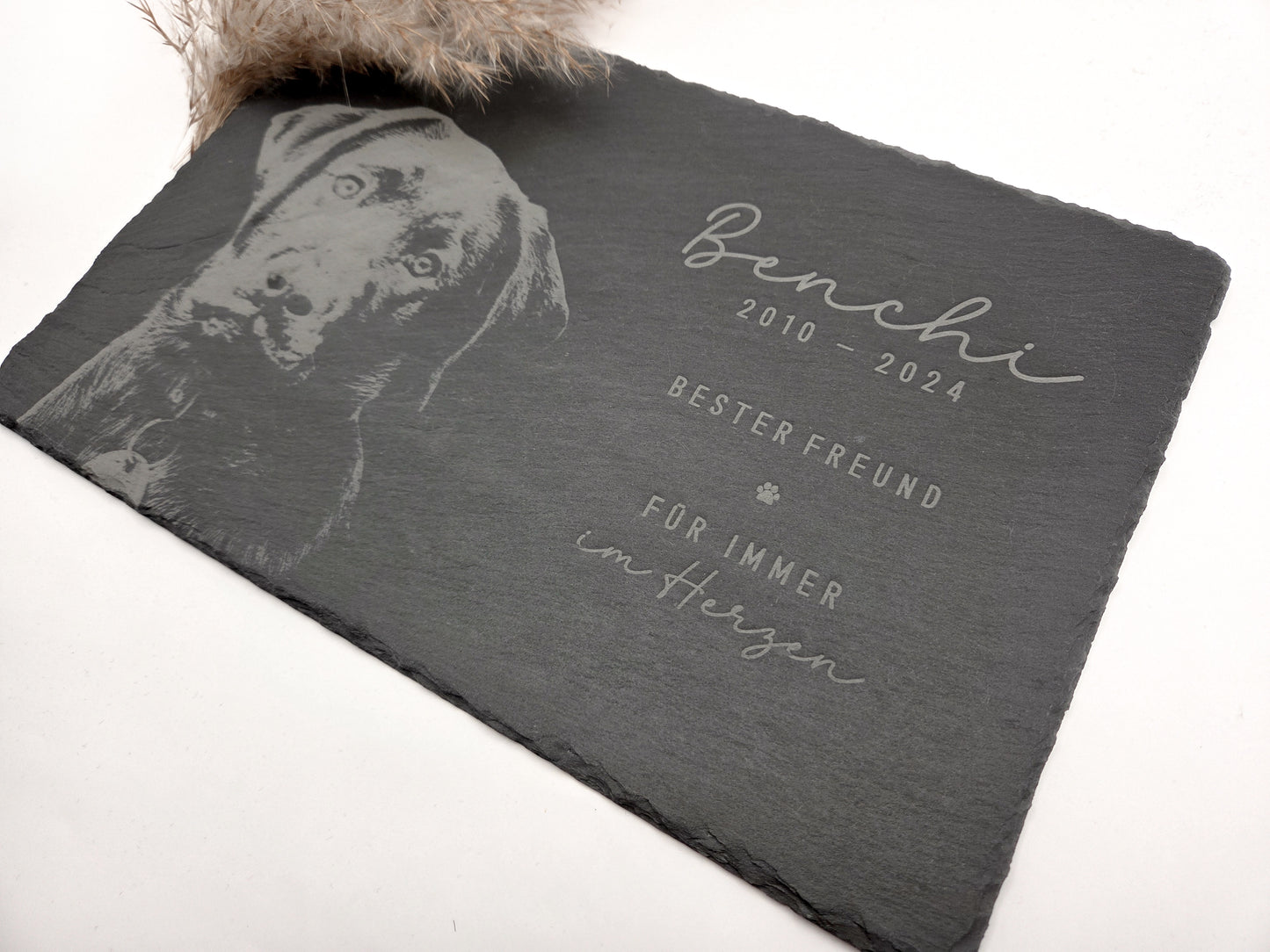 Personalisierte Gedenkplatte für Haustiere aus echtem Naturschiefer mit Foto Gravur. Hochwertige Schieferplatte als Tier Gedenkstein und Grabplatte für Hund oder Katze, lasergraviert mit Haustierfoto, Name, Geburtsdatum, Sterbedatum und zwei individuellen Sprüchen. Natürliche Bruchkante, langlebig, UV- und wetterbeständig. Kein Druck, sondern dauerhafte Gravur im Stein. Ideal als Haustier Gedenkstein, Trauergeschenk und Erinnerung an ein verstorbenes Haustier.