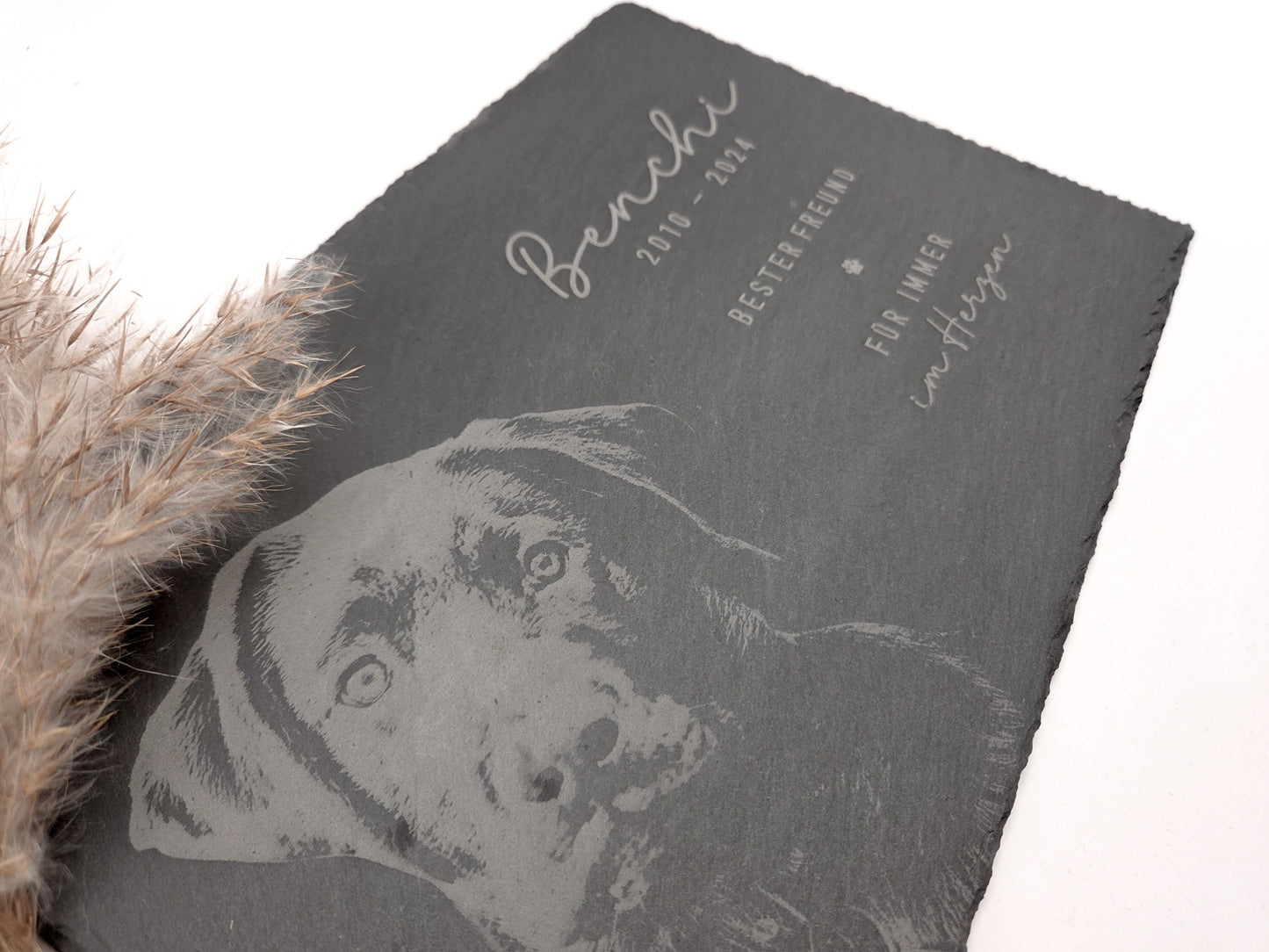 Personalisierte Gedenkplatte für Haustiere aus echtem Naturschiefer mit Foto Gravur. Hochwertige Schieferplatte als Tier Gedenkstein und Grabplatte für Hund oder Katze, lasergraviert mit Haustierfoto, Name, Geburtsdatum, Sterbedatum und zwei individuellen Sprüchen. Natürliche Bruchkante, langlebig, UV- und wetterbeständig. Kein Druck, sondern dauerhafte Gravur im Stein. Ideal als Haustier Gedenkstein, Trauergeschenk und Erinnerung an ein verstorbenes Haustier.