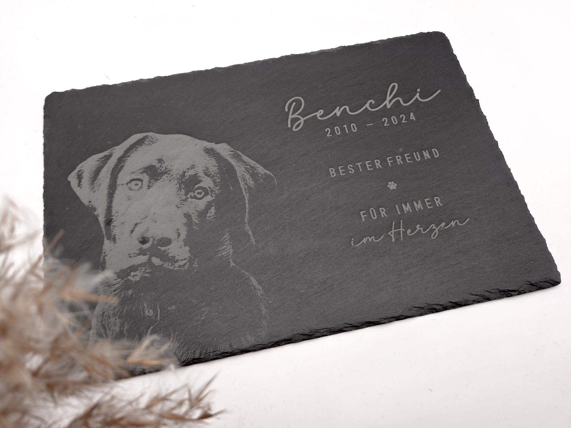 Personalisierte Gedenkplatte für Haustiere aus echtem Naturschiefer mit Foto Gravur. Hochwertige Schieferplatte als Tier Gedenkstein und Grabplatte für Hund oder Katze, lasergraviert mit Haustierfoto, Name, Geburtsdatum, Sterbedatum und zwei individuellen Sprüchen. Natürliche Bruchkante, langlebig, UV- und wetterbeständig. Kein Druck, sondern dauerhafte Gravur im Stein. Ideal als Haustier Gedenkstein, Trauergeschenk und Erinnerung an ein verstorbenes Haustier.
