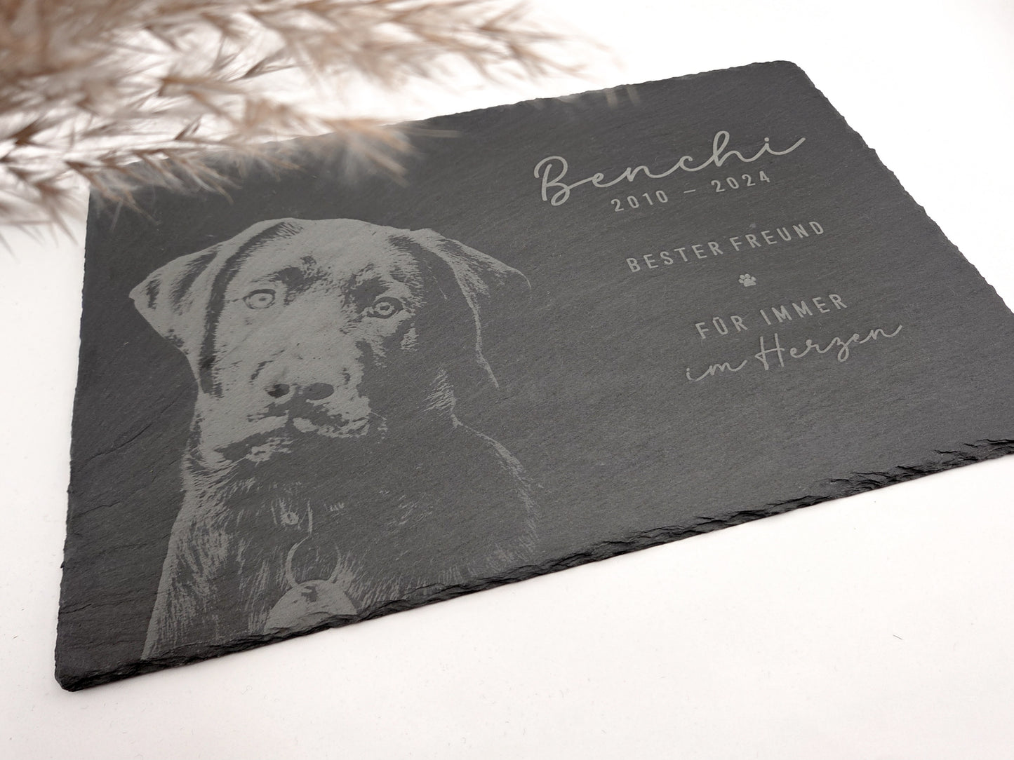 Personalisierte Gedenkplatte für Haustiere aus echtem Naturschiefer mit Foto Gravur. Hochwertige Schieferplatte als Tier Gedenkstein und Grabplatte für Hund oder Katze, lasergraviert mit Haustierfoto, Name, Geburtsdatum, Sterbedatum und zwei individuellen Sprüchen. Natürliche Bruchkante, langlebig, UV- und wetterbeständig. Kein Druck, sondern dauerhafte Gravur im Stein. Ideal als Haustier Gedenkstein, Trauergeschenk und Erinnerung an ein verstorbenes Haustier.