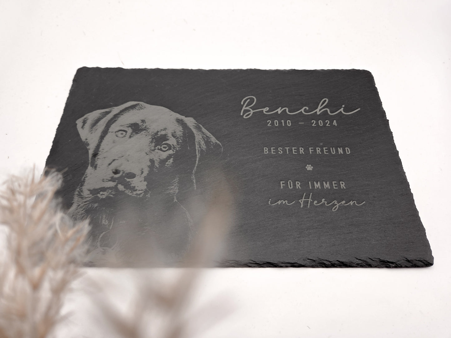 Personalisierte Gedenkplatte für Haustiere aus echtem Naturschiefer mit Foto Gravur. Hochwertige Schieferplatte als Tier Gedenkstein und Grabplatte für Hund oder Katze, lasergraviert mit Haustierfoto, Name, Geburtsdatum, Sterbedatum und zwei individuellen Sprüchen. Natürliche Bruchkante, langlebig, UV- und wetterbeständig. Kein Druck, sondern dauerhafte Gravur im Stein. Ideal als Haustier Gedenkstein, Trauergeschenk und Erinnerung an ein verstorbenes Haustier.