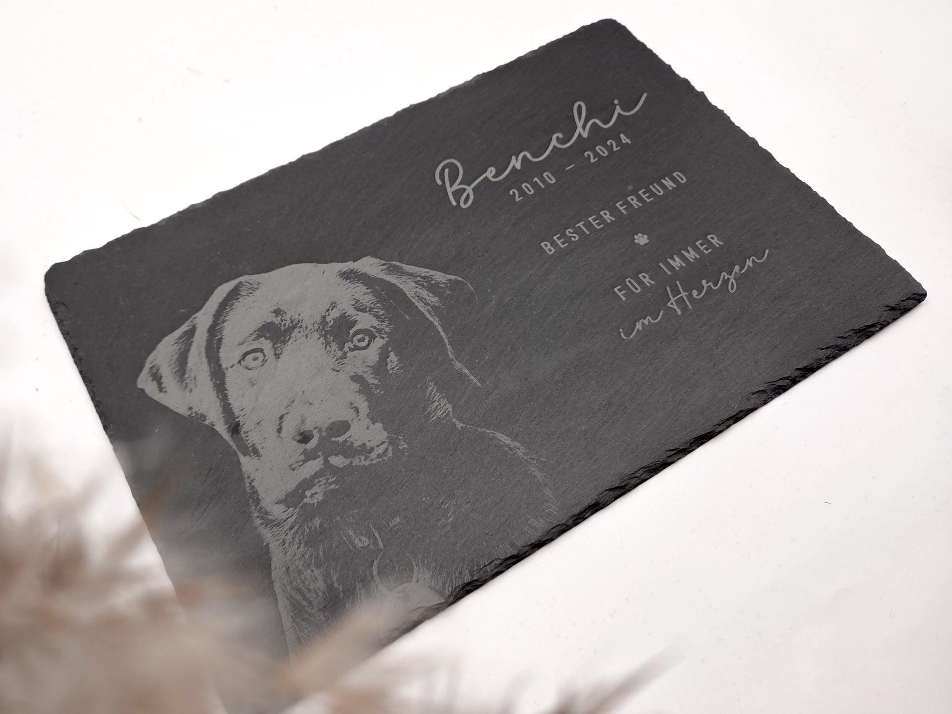 Personalisierte Gedenkplatte für Haustiere aus echtem Naturschiefer mit Foto Gravur. Hochwertige Schieferplatte als Tier Gedenkstein und Grabplatte für Hund oder Katze, lasergraviert mit Haustierfoto, Name, Geburtsdatum, Sterbedatum und zwei individuellen Sprüchen. Natürliche Bruchkante, langlebig, UV- und wetterbeständig. Kein Druck, sondern dauerhafte Gravur im Stein. Ideal als Haustier Gedenkstein, Trauergeschenk und Erinnerung an ein verstorbenes Haustier.