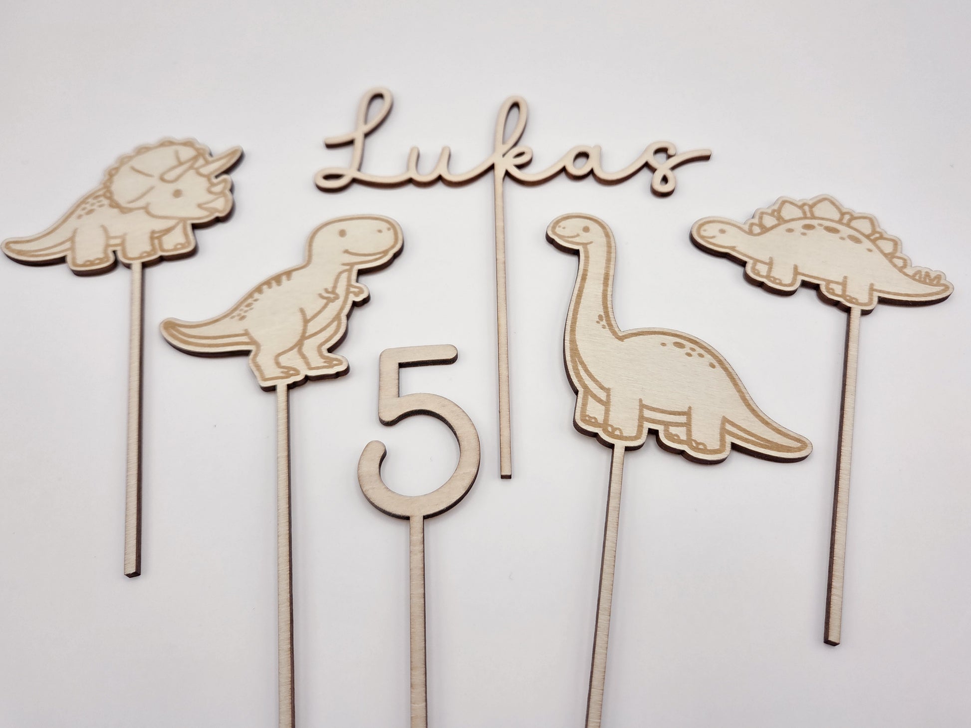 Dino Cake Topper personalisiert aus Holz mit Name und Alter für Dinosaurier Kindergeburtstag Junge. Tortendeko Dinosaurier Set mit Triceratops, T-Rex, Brachiosaurus und Stegosaurus, individueller Namensstecker und Zahl. Hochwertiger Holz Caketopper für Dino Party Deko, Geburtstagstorte Junge 3 4 5 6 Jahre, natürliche Tortendekoration für Naked Cake, Buttercremetorte oder Fondantkuchen. Personalisierte Geburtstagsdeko Holz kaufen bei leoundlu.de.