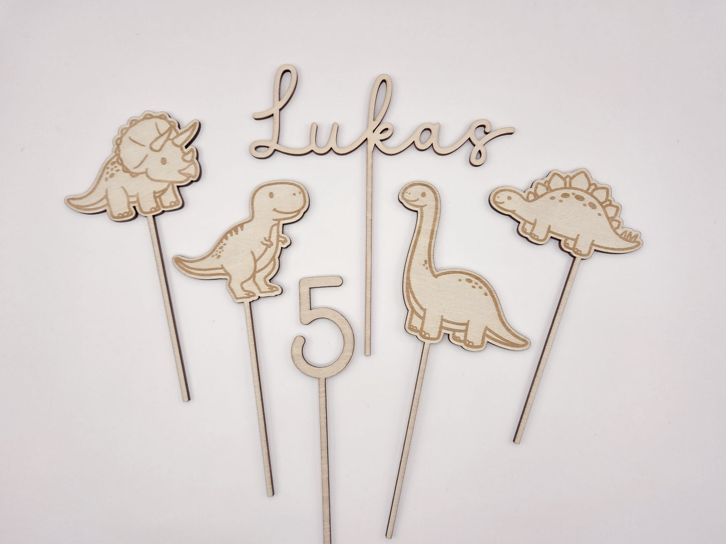 Dino Cake Topper personalisiert aus Holz mit Name und Alter für Dinosaurier Kindergeburtstag Junge. Tortendeko Dinosaurier Set mit Triceratops, T-Rex, Brachiosaurus und Stegosaurus, individueller Namensstecker und Zahl. Hochwertiger Holz Caketopper für Dino Party Deko, Geburtstagstorte Junge 3 4 5 6 Jahre, natürliche Tortendekoration für Naked Cake, Buttercremetorte oder Fondantkuchen. Personalisierte Geburtstagsdeko Holz kaufen bei leoundlu.de.