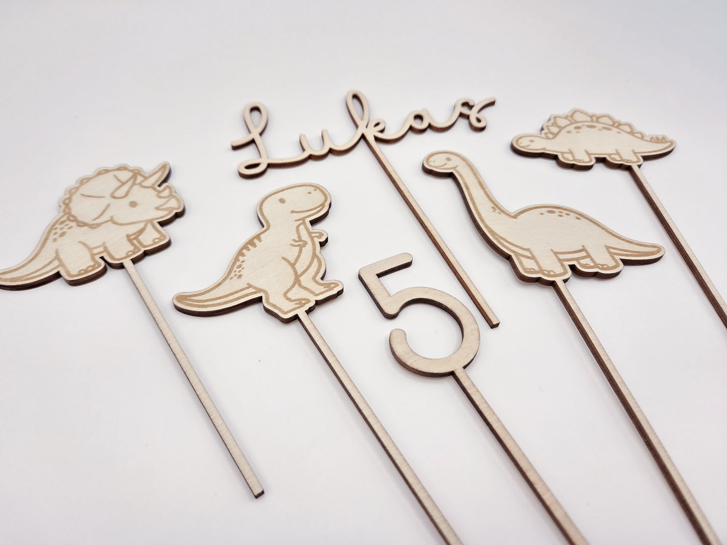 Dino Cake Topper personalisiert aus Holz mit Name und Alter für Dinosaurier Kindergeburtstag Junge. Tortendeko Dinosaurier Set mit Triceratops, T-Rex, Brachiosaurus und Stegosaurus, individueller Namensstecker und Zahl. Hochwertiger Holz Caketopper für Dino Party Deko, Geburtstagstorte Junge 3 4 5 6 Jahre, natürliche Tortendekoration für Naked Cake, Buttercremetorte oder Fondantkuchen. Personalisierte Geburtstagsdeko Holz kaufen bei leoundlu.de.