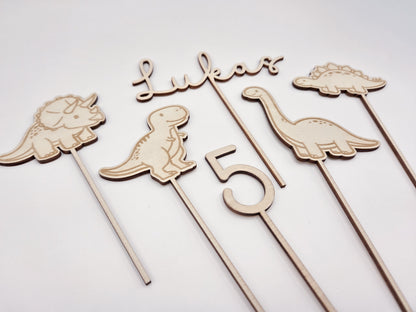 Dino Cake Topper personalisiert aus Holz mit Name und Alter für Dinosaurier Kindergeburtstag Junge. Tortendeko Dinosaurier Set mit Triceratops, T-Rex, Brachiosaurus und Stegosaurus, individueller Namensstecker und Zahl. Hochwertiger Holz Caketopper für Dino Party Deko, Geburtstagstorte Junge 3 4 5 6 Jahre, natürliche Tortendekoration für Naked Cake, Buttercremetorte oder Fondantkuchen. Personalisierte Geburtstagsdeko Holz kaufen bei leoundlu.de.
