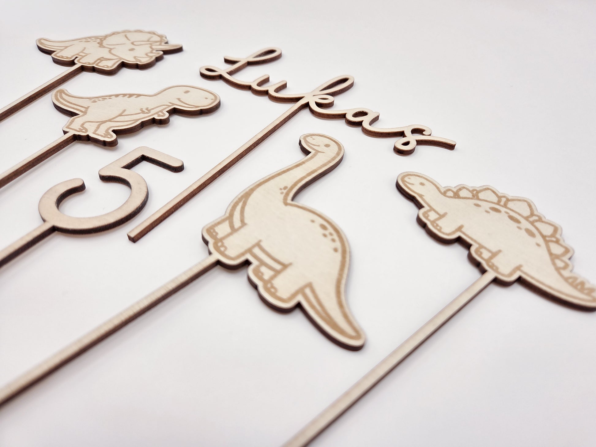 Dino Cake Topper personalisiert aus Holz mit Name und Alter für Dinosaurier Kindergeburtstag Junge. Tortendeko Dinosaurier Set mit Triceratops, T-Rex, Brachiosaurus und Stegosaurus, individueller Namensstecker und Zahl. Hochwertiger Holz Caketopper für Dino Party Deko, Geburtstagstorte Junge 3 4 5 6 Jahre, natürliche Tortendekoration für Naked Cake, Buttercremetorte oder Fondantkuchen. Personalisierte Geburtstagsdeko Holz kaufen bei leoundlu.de.