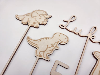 Dino Cake Topper personalisiert aus Holz mit Name und Alter für Dinosaurier Kindergeburtstag Junge. Tortendeko Dinosaurier Set mit Triceratops, T-Rex, Brachiosaurus und Stegosaurus, individueller Namensstecker und Zahl. Hochwertiger Holz Caketopper für Dino Party Deko, Geburtstagstorte Junge 3 4 5 6 Jahre, natürliche Tortendekoration für Naked Cake, Buttercremetorte oder Fondantkuchen. Personalisierte Geburtstagsdeko Holz kaufen bei leoundlu.de.