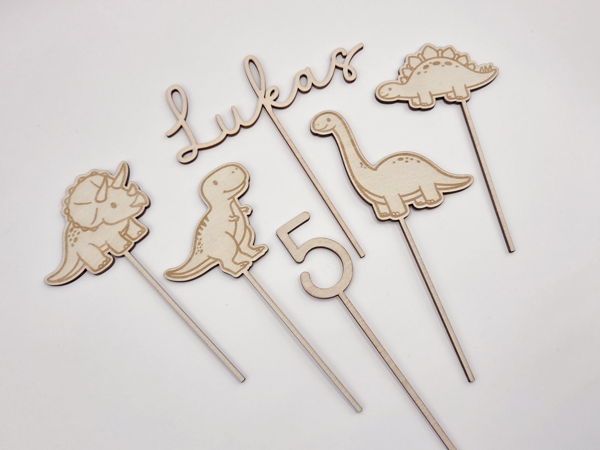 Dino Cake Topper personalisiert aus Holz mit Name und Alter für Dinosaurier Kindergeburtstag Junge. Tortendeko Dinosaurier Set mit Triceratops, T-Rex, Brachiosaurus und Stegosaurus, individueller Namensstecker und Zahl. Hochwertiger Holz Caketopper für Dino Party Deko, Geburtstagstorte Junge 3 4 5 6 Jahre, natürliche Tortendekoration für Naked Cake, Buttercremetorte oder Fondantkuchen. Personalisierte Geburtstagsdeko Holz kaufen bei leoundlu.de.