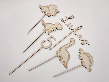Dino Cake Topper personalisiert aus Holz mit Name und Alter für Dinosaurier Kindergeburtstag Junge. Tortendeko Dinosaurier Set mit Triceratops, T-Rex, Brachiosaurus und Stegosaurus, individueller Namensstecker und Zahl. Hochwertiger Holz Caketopper für Dino Party Deko, Geburtstagstorte Junge 3 4 5 6 Jahre, natürliche Tortendekoration für Naked Cake, Buttercremetorte oder Fondantkuchen. Personalisierte Geburtstagsdeko Holz kaufen bei leoundlu.de.