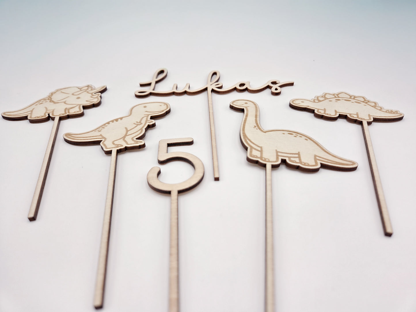 Dino Cake Topper personalisiert aus Holz mit Name und Alter für Dinosaurier Kindergeburtstag Junge. Tortendeko Dinosaurier Set mit Triceratops, T-Rex, Brachiosaurus und Stegosaurus, individueller Namensstecker und Zahl. Hochwertiger Holz Caketopper für Dino Party Deko, Geburtstagstorte Junge 3 4 5 6 Jahre, natürliche Tortendekoration für Naked Cake, Buttercremetorte oder Fondantkuchen. Personalisierte Geburtstagsdeko Holz kaufen bei leoundlu.de.