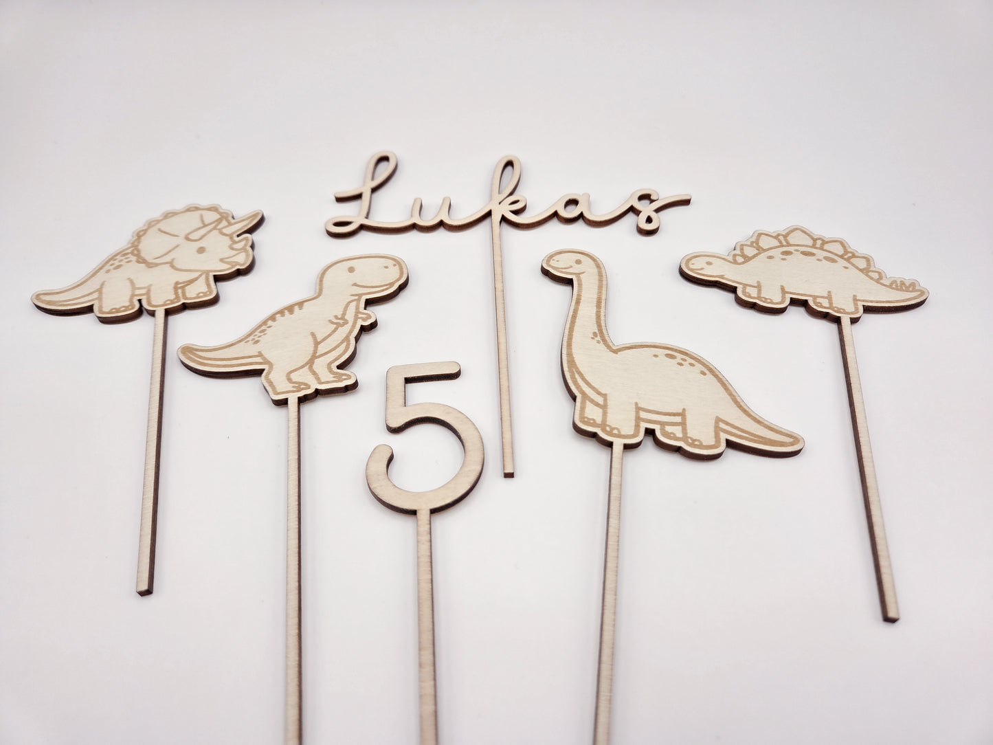 Dino Cake Topper personalisiert aus Holz mit Name und Alter für Dinosaurier Kindergeburtstag Junge. Tortendeko Dinosaurier Set mit Triceratops, T-Rex, Brachiosaurus und Stegosaurus, individueller Namensstecker und Zahl. Hochwertiger Holz Caketopper für Dino Party Deko, Geburtstagstorte Junge 3 4 5 6 Jahre, natürliche Tortendekoration für Naked Cake, Buttercremetorte oder Fondantkuchen. Personalisierte Geburtstagsdeko Holz kaufen bei leoundlu.de.