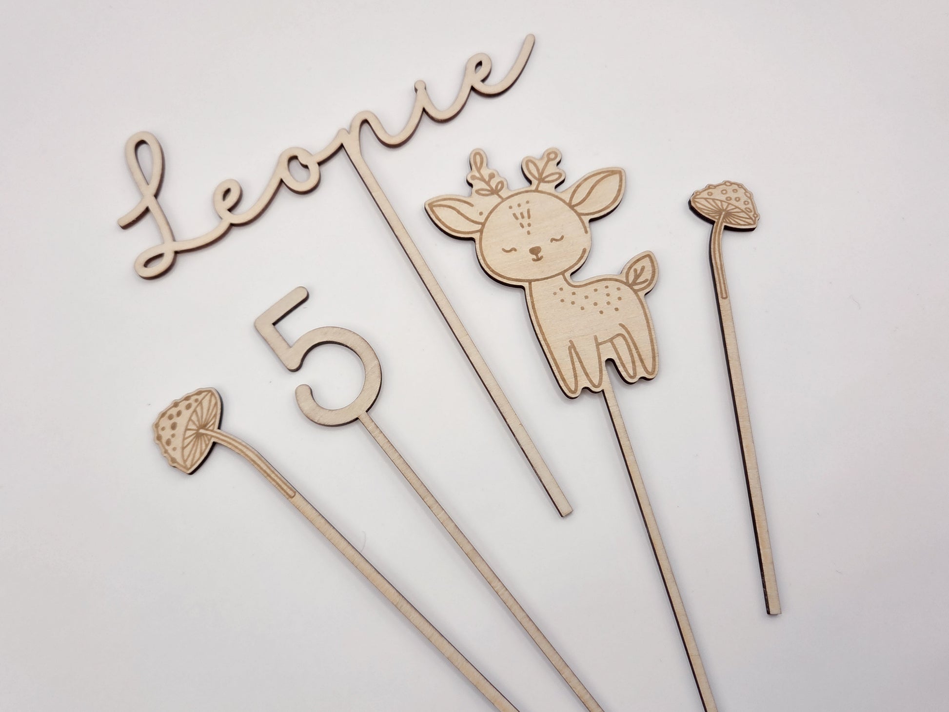 Personalisierter Cake Topper aus Holz mit Name Leonie und Zahl 5 im Waldtiere Design für Kindergeburtstag. Hochwertiger Holz Tortenstecker mit Reh Motiv, graviert und gelasert, perfekte Tortendeko für Naked Cake, Boho Geburtstag, Natur Kinderparty und Scandi Geburtstagsdeko. Nachhaltige Cake Topper personalisiert mit Name und Alter, Waldtier Party Dekoration für Mädchen und Jungen, individuelle Holz Geburtstagsdeko für 1. 2. 3. 4. 5. Geburtstag handgefertigt von Leo&Lu.