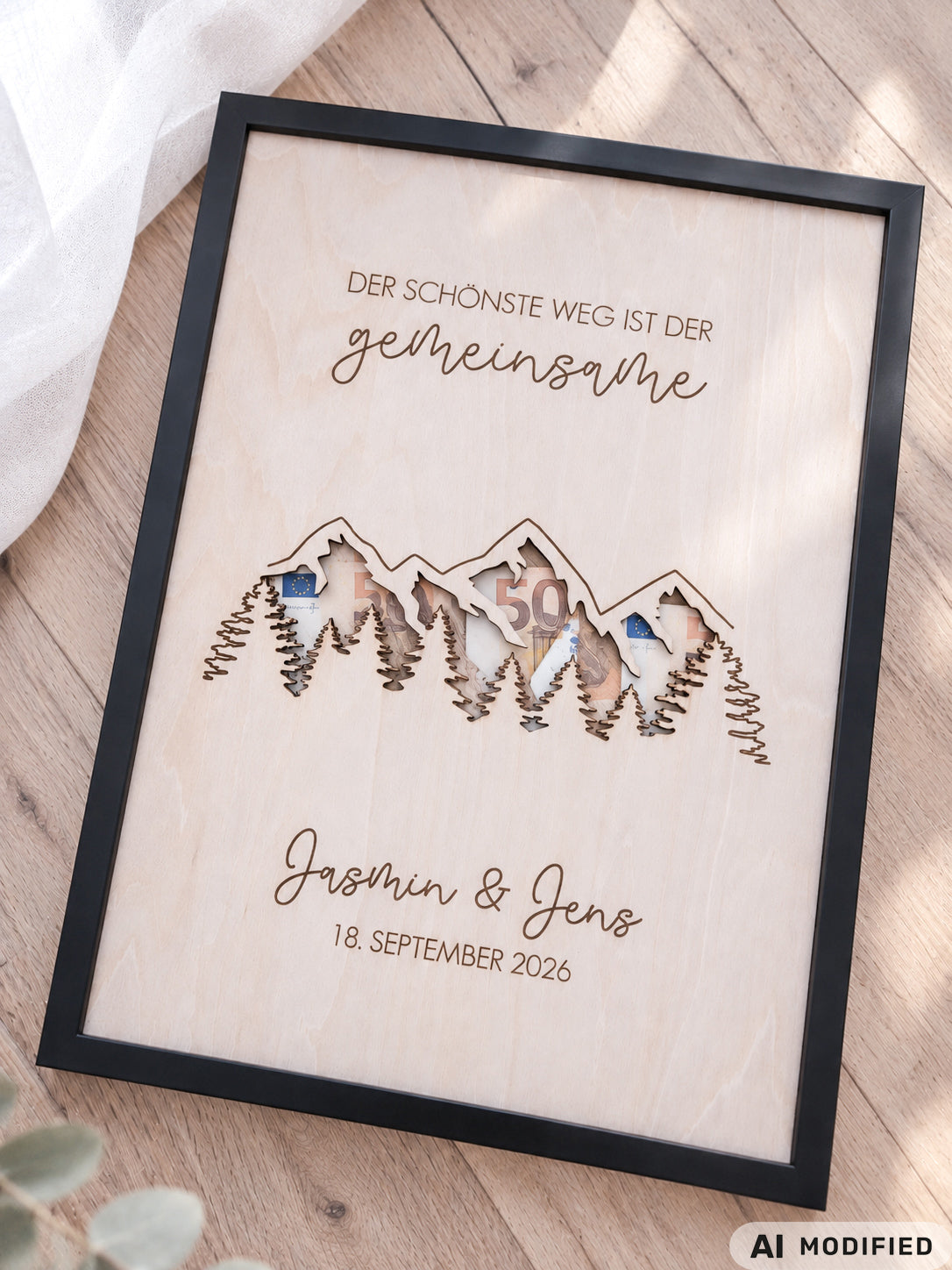 Personalisiertes Geldgeschenk zur Hochzeit aus Holz mit filigran ausgeschnittener Berg- und Waldlandschaft. Hinter den Bergen lassen sich Geldscheine dekorativ platzieren. Mit Gravur „Der schönste Weg ist der gemeinsame“, Namen des Brautpaares und Hochzeitsdatum. Originelles Hochzeitsgeschenk für Braut und Bräutigam, ideal als Geldgeschenk zur Hochzeit, personalisierte Hochzeitsdeko und besondere Geschenkidee für Paare, Bergliebhaber, Wanderfreunde und Naturliebhaber.
