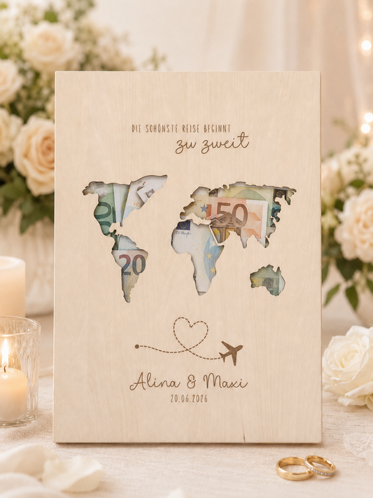 Personalisiertes Geldgeschenk zur Hochzeit aus hellem Holz mit filigraner Weltkarte und eingesteckten Euro-Geldscheinen hinter den Kontinenten. Die gravierte Aufschrift „Die schönste Reise beginnt zu zweit“ sowie die Namen des Brautpaares und das Hochzeitsdatum machen dieses Hochzeitsgeschenk zu einer besonderen Erinnerung. Das Holzbild steht in einer romantischen Hochzeitskulisse mit weißen Rosen, Kerzenlicht, Eheringen und eleganter Tischdekoration. Perfekt als Geldgeschenk für Flitterwochen, Reisekasse o
