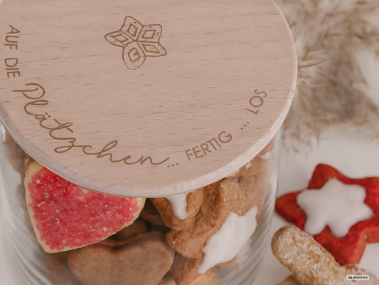 Glas mit Holzdeckel und Gravur „Auf die Plätzchen … fertig … los“ gefüllt mit Weihnachtsplätzchen. Daneben liegen Zimtsterne und Vanillekipferl auf hellem Hintergrund – stimmungsvolles, nordisch-cleanes Weihnachtsmotiv.