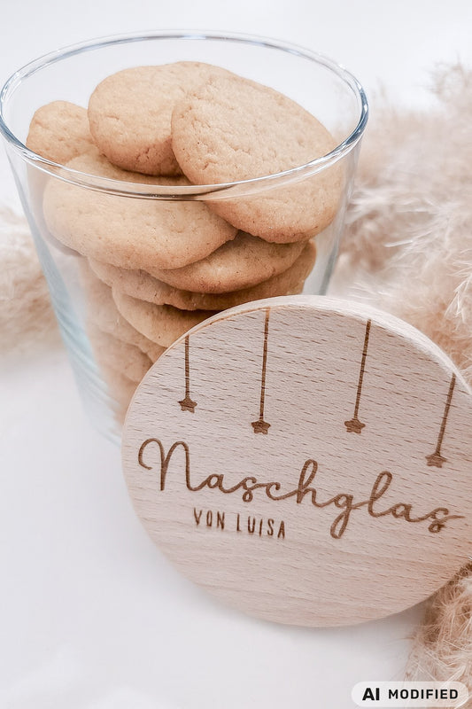 Runder Holzdeckel mit graviertem Schriftzug „Naschglas von Luisa“ und Sternanhängern, auf Glas liegend – personalisierte Geschenkidee.