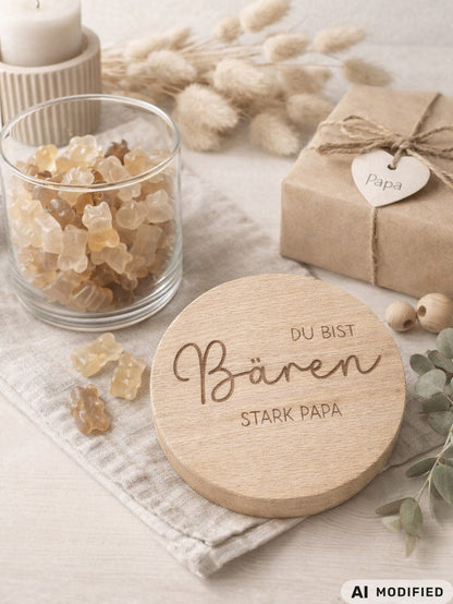 Geschenkglas mit graviertem Holzdeckel für Papa, gefüllt mit hellen Gummibärchen im skandinavischen Stil dekoriert. Der Deckel trägt die liebevolle Gravur „Du bist Bären stark Papa“ mit Herzmotiv. Perfekte Geschenkidee zum Vatertag, Geburtstag oder als kleines Dankeschön für den besten Papa. Modernes, minimalistisches Setting mit Naturmaterialien wie Holz, Trockenblumen und Kerze sorgt für eine warme, hochwertige Präsentation und macht dieses personalisierte Papa Geschenk besonders emotional und einzigartig
