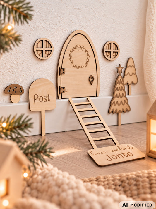 Personalisierbare Holz-Wichteltür mit Leiter, Briefkasten, Pilz und zwei Tannenbäumen an einer weißen Sockelleiste im Kinderzimmer, auf hellblauer Wand mit weißen Punkten montiert.