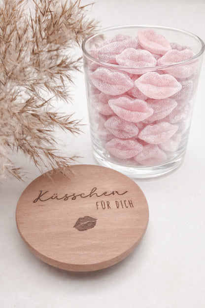 Dekoratives Geschenkglas aus klarem Glas mit hochwertigem Buchenholzdeckel und feiner Gravur „Küsschen für dich“. Das minimalistische Design im Scandi-Stil macht das Glas zu einer liebevollen Geschenkidee für Valentinstag, Muttertag, Geburtstag oder als kleine Aufmerksamkeit für Herzensmenschen. Ideal zum individuellen Befüllen mit Süßigkeiten oder Botschaften. Die abgebildeten Süßigkeiten sind Dekoration und nicht im Lieferumfang enthalten.