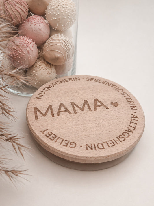 Geschenkglas Mama mit Holzdeckel Gravur personalisiert Muttertag Geschenk liebevoll dekoriert mit Pralinen in sanften Rosa und Cremefarben Glas mit Holzdeckel hochwertig graviert MAMA mit Herz und liebevollen Worten Geschenkidee für Mama Geburtstag Weihnachten kleines Geschenk für Mutter Glas befüllt mit edlen Pralinen skandinavischer Stil hell freundlich modern Geschenkglas Mama personalisiert nachhaltig wiederverwendbar Süßigkeiten nicht enthalten