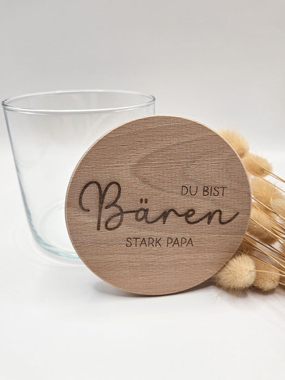 Geschenkglas mit graviertem Holzdeckel für Papa, gefüllt mit hellen Gummibärchen im skandinavischen Stil dekoriert. Der Deckel trägt die liebevolle Gravur „Du bist Bären stark Papa“ mit Herzmotiv. Perfekte Geschenkidee zum Vatertag, Geburtstag oder als kleines Dankeschön für den besten Papa. Modernes, minimalistisches Setting mit Naturmaterialien wie Holz, Trockenblumen und Kerze sorgt für eine warme, hochwertige Präsentation und macht dieses personalisierte Papa Geschenk besonders emotional und einzigartig