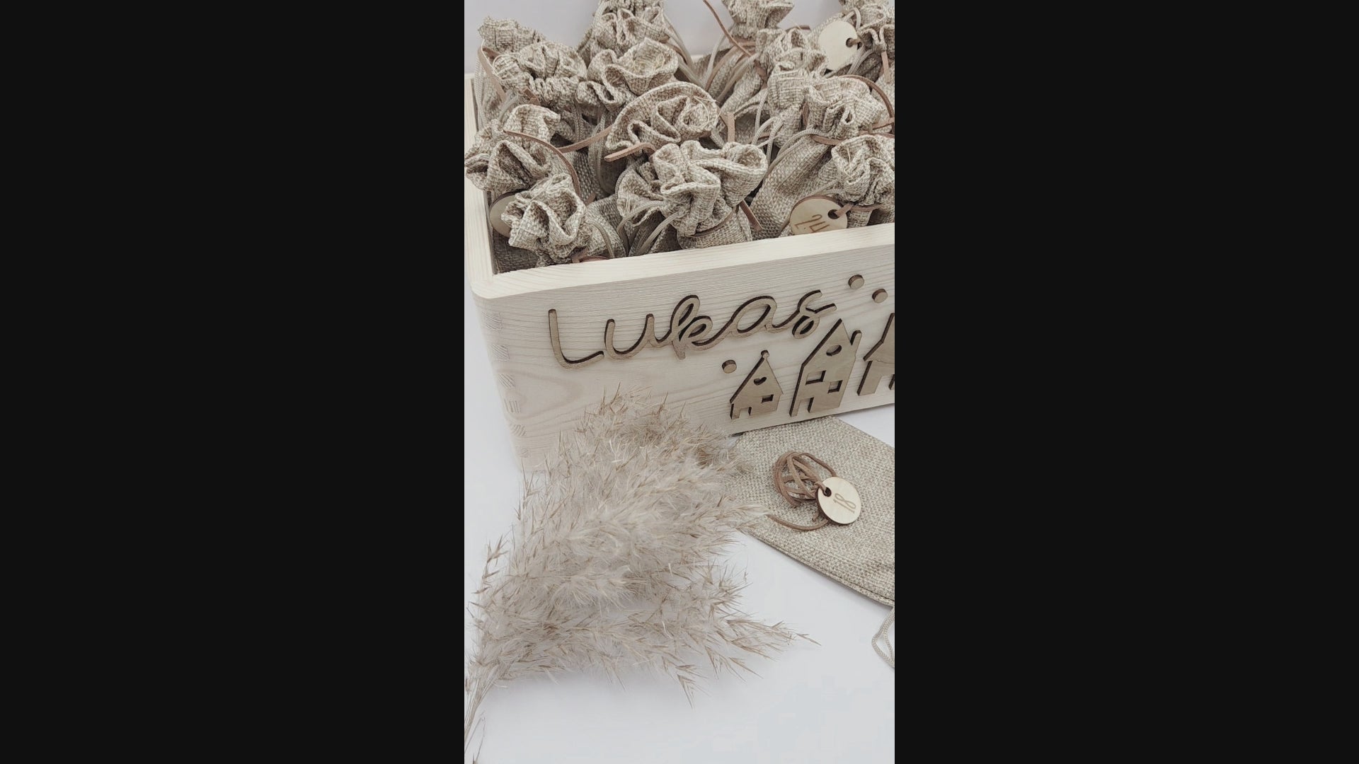 Personalisierte Adventskiste aus Holz mit 3D-Weihnachtsdorf, 24 Jutesäckchen und Zahlenanhängern im hellen skandinavischen Leo&Lu-Stil.