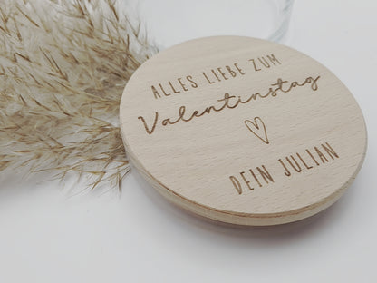 Personalisiertes Geschenkglas zum Valentinstag mit graviertem Holzdeckel und individueller Namensgravur. Hochwertiges Glas gefüllt mit Schokoladenherzen in Rosa, Weiß und Vollmilch, dekorativ angerichtet. Romantisches Valentinstagsgeschenk für Freundin, Geschenk für Freund, Geschenk für Partner oder Ehemann. Personalisiertes Schokoladengeschenk mit Gravur, Liebesgeschenk personalisiert, Geschenkidee Valentinstag, Geschenk für Paare, liebevolle Aufmerksamkeit, handgemachtes Geschenk, hochwertig und einzigart